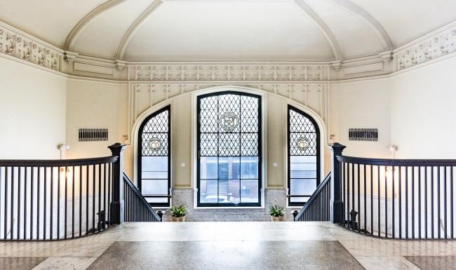 a large room with a large glass window and a large arched doorway