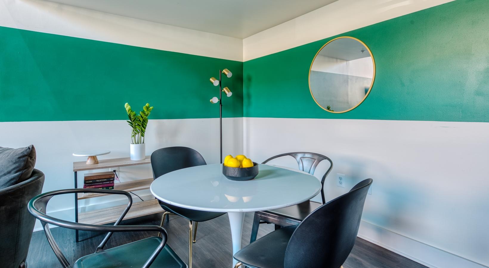 a room with a round mirror and a round table with chairs